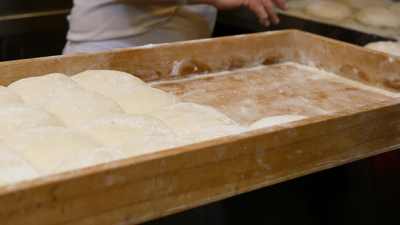 Panettiere che prepara l'impasto in un vassoio di legno