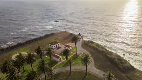 cinematic sunset of point vicente lighthouse, aerial orbit view over ocean, palos verdes