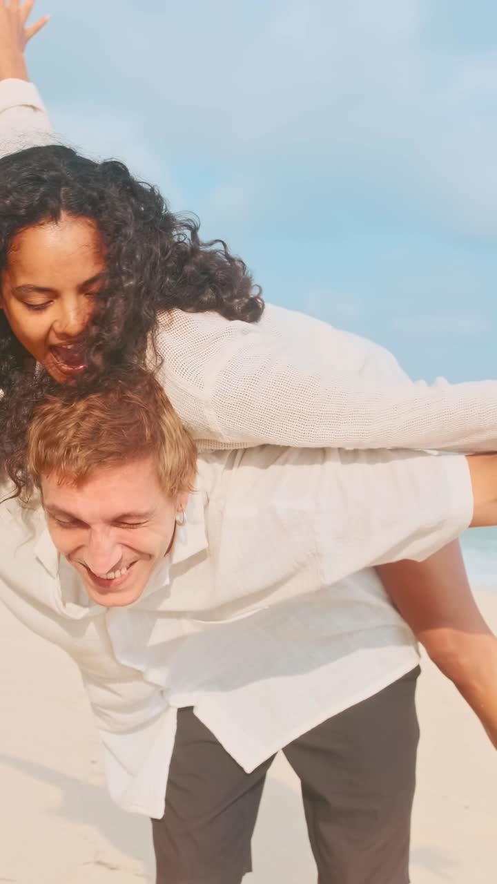 Happy couple enjoying beach playtime together in sunny weather