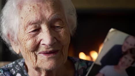 an elderly woman reminiscing by the fire, sharing cherished memories through photographs in a warm and inviting home environment