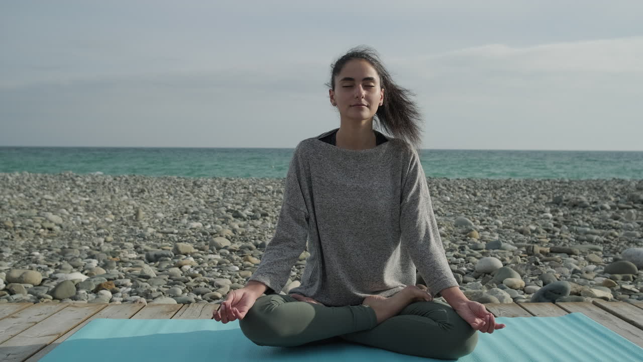 mujer meditando en una playa
