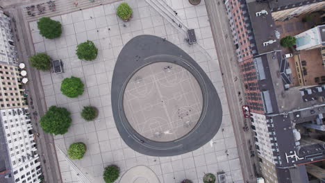 Un-Vistazo-Desde-Arriba-Revela-Una-Cancha-De-Baloncesto-En-Israels-Plads-En-Copenhague,-Un-Centro-De-Actividad-Durante-El-Día,-Donde-Convergen-Personas-Y-Elementos-De-La-Ciudad