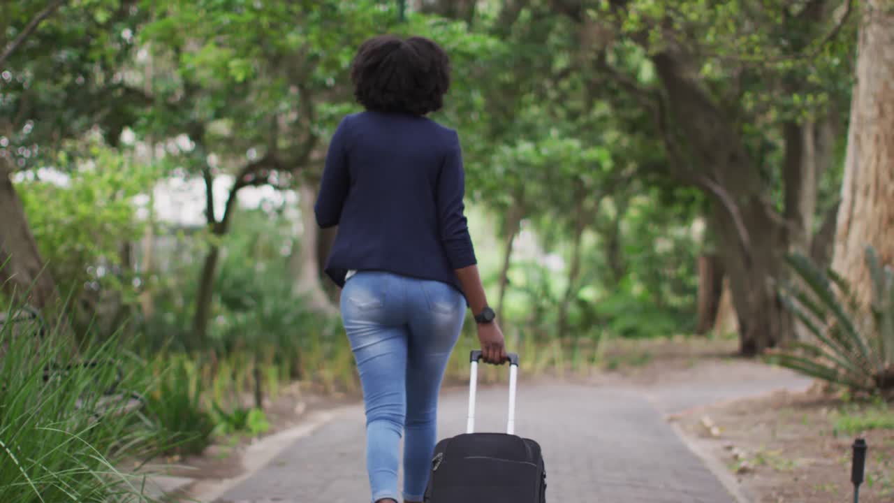 mulher afro-americana usando máscara de rosto no parque