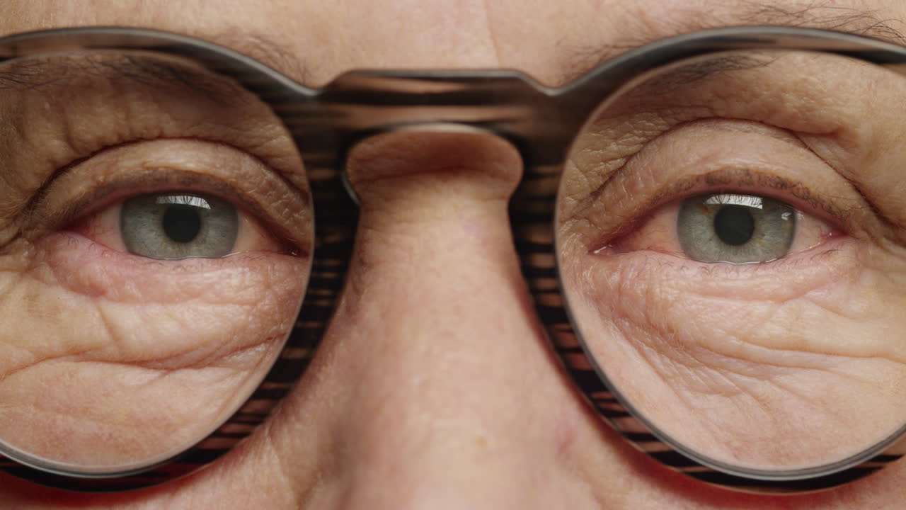 가까운 거시적인 눈 안경을 쓰고 있는  ⁇ 은 여자 노화된 아름다움 건강한 시력 개념