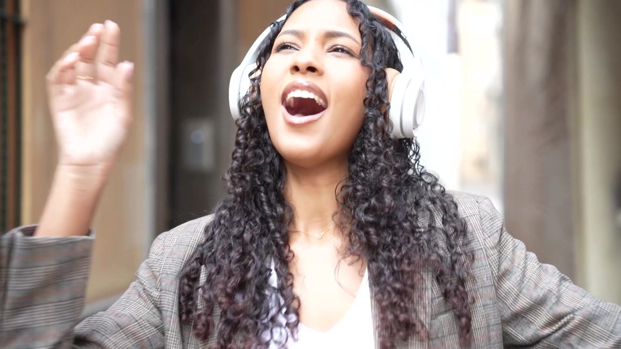 Una giovane donna gioiosa che prospera e si gode musica vibrante in un ambiente di vicolo urbano