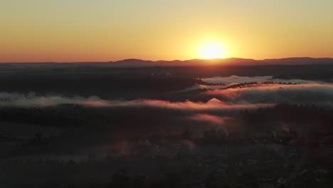 golden sunrise over a misty valley and forest landscape