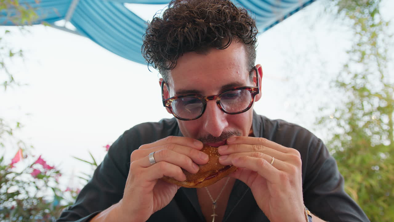 Man Savouring The Gourmet Burger On A Sunny Day At The Beach Resort