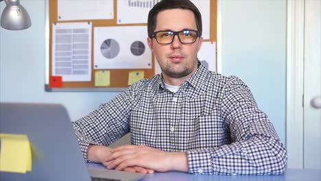 hombre sentado en su escritorio trabajando en una computadora portátil