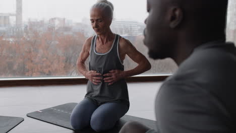 senior woman practicing yoga with instructor