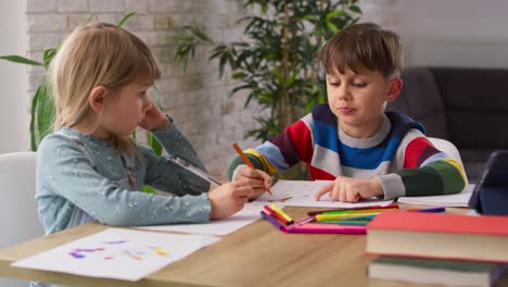 handheld video of polite sibling doing homework together at home