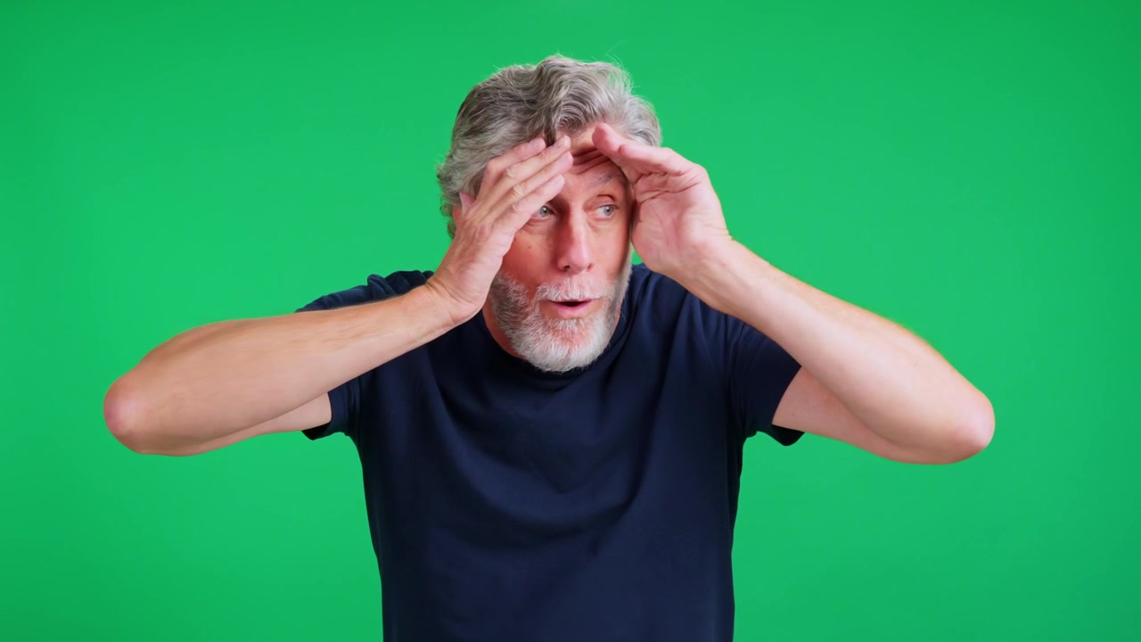 Senior man being surprised on green screen background