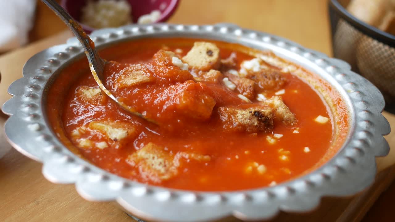 un plato de sopa de tomate con croutones