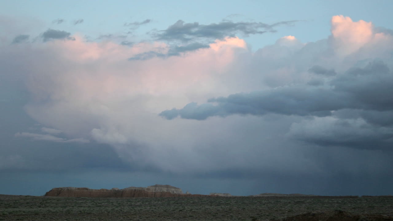 las nubes de tormenta en la hora dorada toman un tono apagado de rosa y azul y luego se desvanecen en la oscuridad