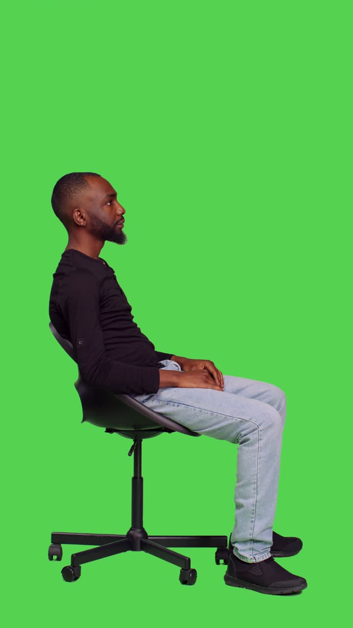Vertikales Video: Profil einer afroamerikanischen Person, die auf einem Stuhl auf etwas wartet