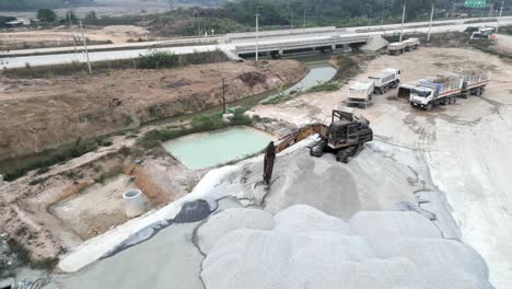 aerial view of heavy machinery and material piles at a construction site