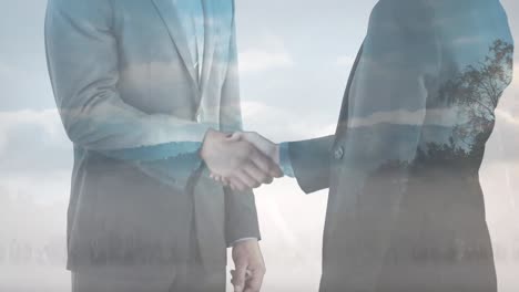 animation of midsection of caucasian businessmen shaking hands over landscape