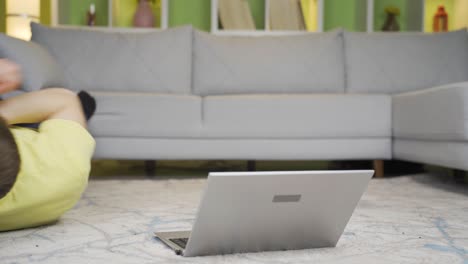 young man rejoicing and being happy on laptop at home.