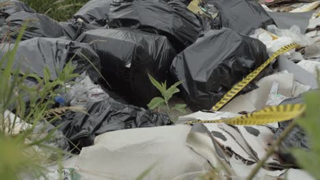 plastic bag liners of garbage dumped in countryside medium shot