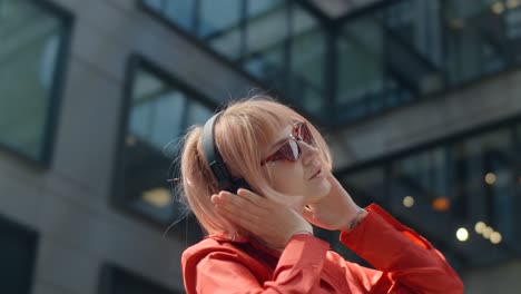 stylish woman listening to music in the city