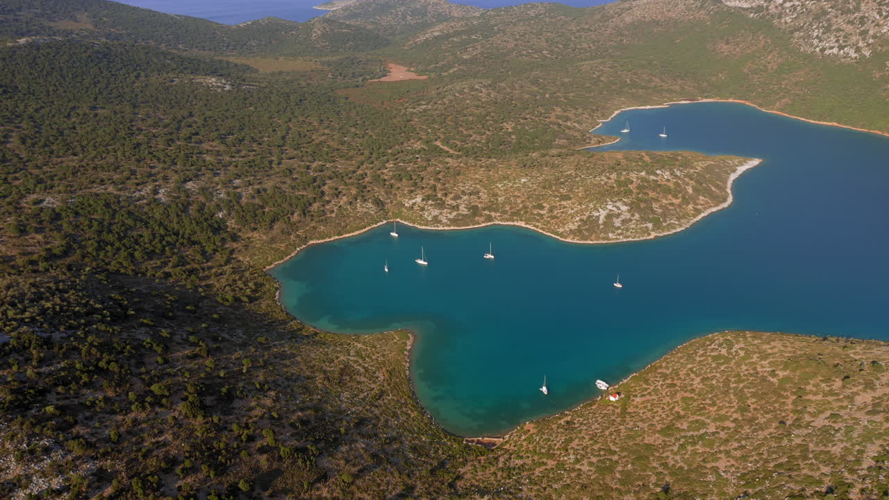 Aerial: Panoramic shot of planitis bay of the island of Kira Panagia in Sporades, Greece with crystal clear water