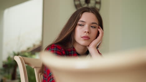 disheartened woman sits in kitchen room. sad lady grapples with stress of uncertain future particularly pressing challenges of financial problems