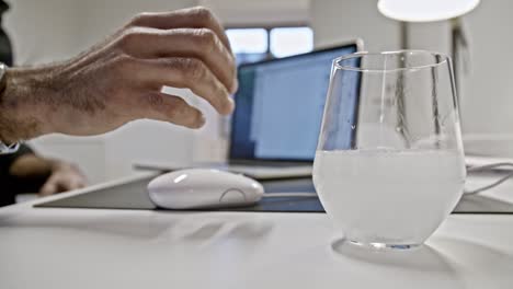 Mano-De-Persona-Blanca-Tomando-Un-Vaso-De-Agua-Con-Una-Tableta-Efervescente-Mientras-Trabaja