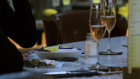 Two-young-ladies-enjoying-champagne-and-eating-oysters-in-Barcelona's-market