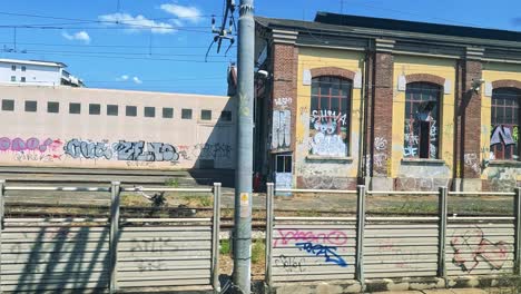 train travels past graffiti-covered buildings