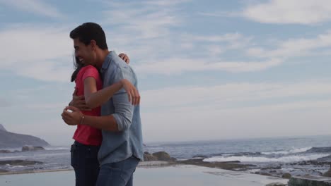 una joven pareja enamorada abrazándose.