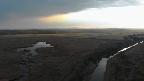 Río-Y-Pequeño-Lago-En-El-Valle-Verde-Al-Atardecer---Toma-Aérea