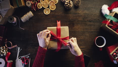 Hände-Von-Oben,-Die-Weihnachtsgeschenke-Am-Holzschreibtisch-Einpacken---Roter-Epischer-Drache