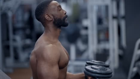 athletic african american man prepares to perform dumbbell press