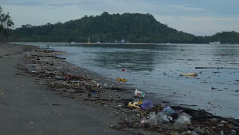 Slow-motion-mid-shot-of-rubbish-in-shore-line-on-a-beach-in-Lombok,-Indonesia