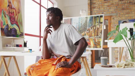 portrait of pensive african american male painter in artist studio