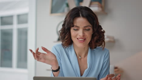 cheerful woman talking laptop web camera gesturing in modern office closeup