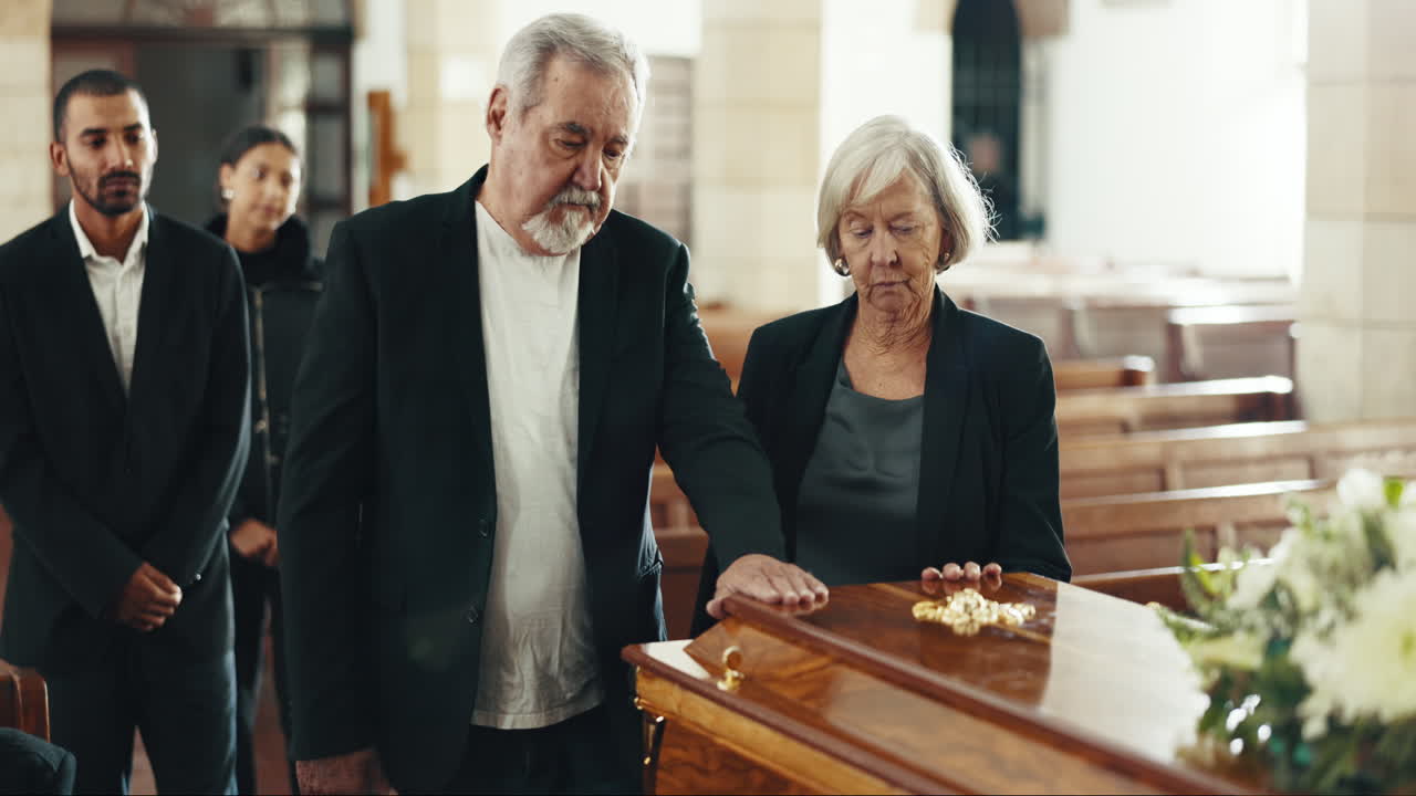 Funerale, chiesa e coppia con la mano sulla bara