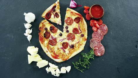 italian pizza on wooden table with vegetables and spices