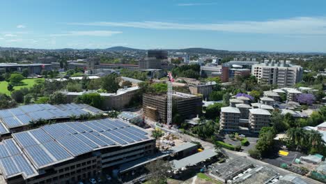 toma rotacional de drones de la grúa del sitio de construcción trabajando en el campus de la uq de la universidad de brisbanes en queensland