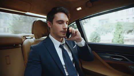 portrait of handsome business man calling on smartphone in comfortable car.