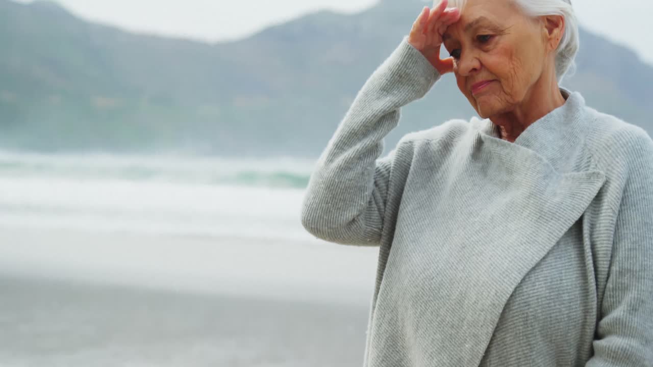 Senior woman in tension standing on beach