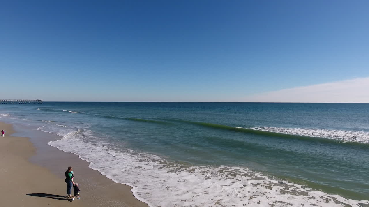잔잔한 파도에서 해변으로 날아가는 드론 샷
