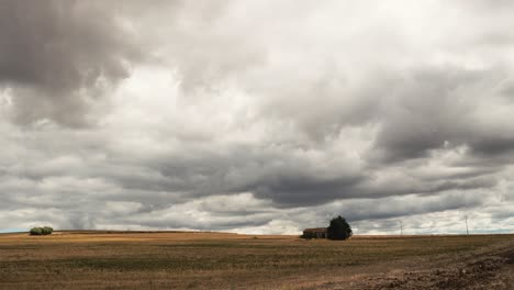 timelapse of heavy clouds moving over a farmfield with a little pittoresque house on it in south italy in 4k