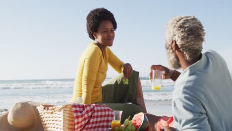Glückliches-Afroamerikanisches-Paar-Beim-Picknick-Am-Sonnigen-Strand