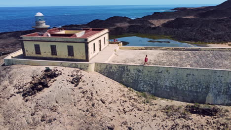 una mujer caminando a lo largo del borde de un monumento en la isla de los lobos