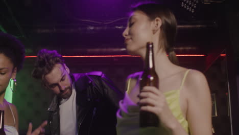 group of four young friends drinking beer and dancing at disco 2