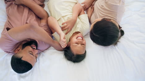 familia feliz, niño y cosquillas en el dormitorio