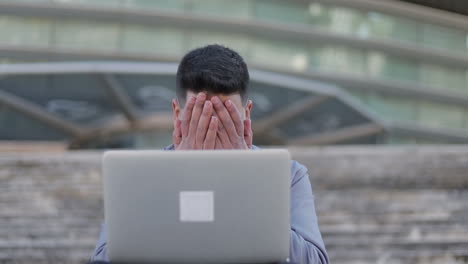 Trauriger-Junger-Mann,-Der-Auf-Den-Laptop-Schaut-Und-Sich-Das-Gesicht-Reibt