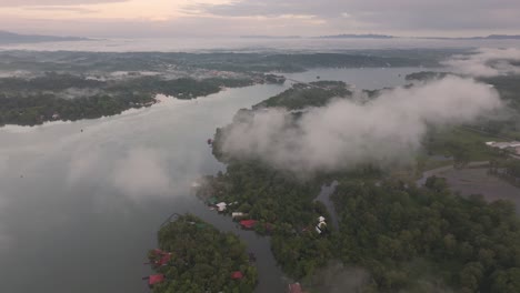 Aerial-view-of-Rio-dulce-river-during-a-foggy-morning,-sunrise