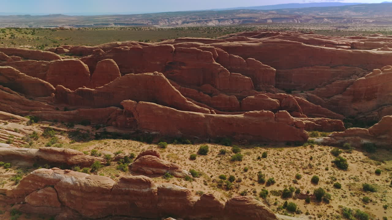 Oddly-shaped rocks grouped together in the sunlit landscape. National Park panorama in Utah from aerial perspective.