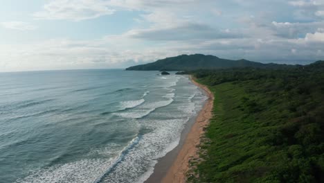 beautiful 4k aerial drone shot of the tropical pacific paradise beach playa grande at the seaside in costa rica with waves, jungle and sand